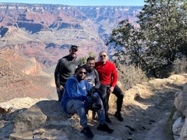 giving and receiving | Friedreich's Ataxia News | Matt takes a break in between video shoots at the Grand Canyon, with videographer staff and his personal trainer. The four men pose before the breathtaking canyon scenery