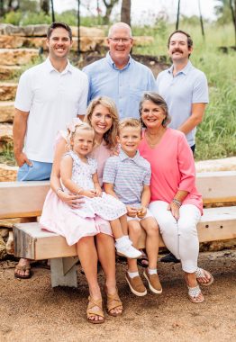 parents | Friedreich's Ataxia News | a family photograph with three men standing and, sitting in front of them, the young blond writer, two children, and another woman, all in the outdoors