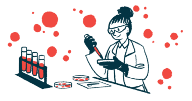 A scientist uses a pipette to fill a petri dish in a laboratory, with a rack of text tubes nearby.