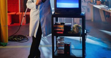Bill Nye the Science Guy is pictured leaning against a video monitor in his lab.