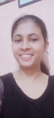 A headshot features a young woman smiling. Her hair is tied back and she's wearing a black blouse.