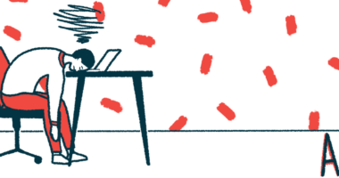 The acronym AAC is seen on the floor nearby a person seated at a table but sleeping on a laptop keyboard.