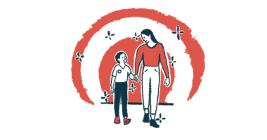 A mother and son walk while holding hands and looking at each other.