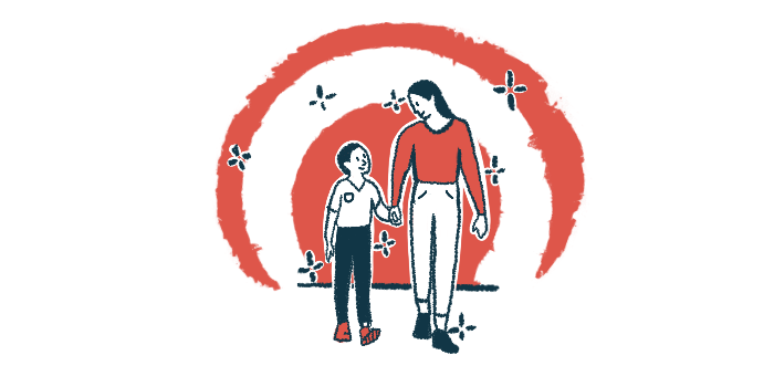 A mother and son walk while holding hands and looking at each other.